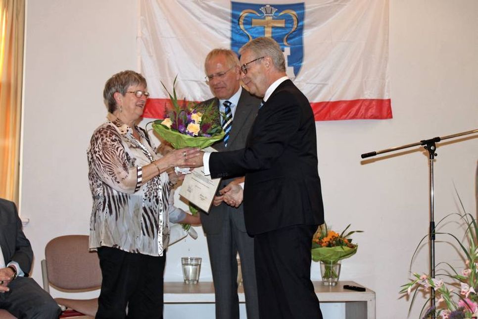 Landrat Reinhard Sager (Mitte) und Kreispräsident Ulrich Rüder bei der feierlichen Ehrung von Helga Richter im Festsaal vom Kloster Cismar.