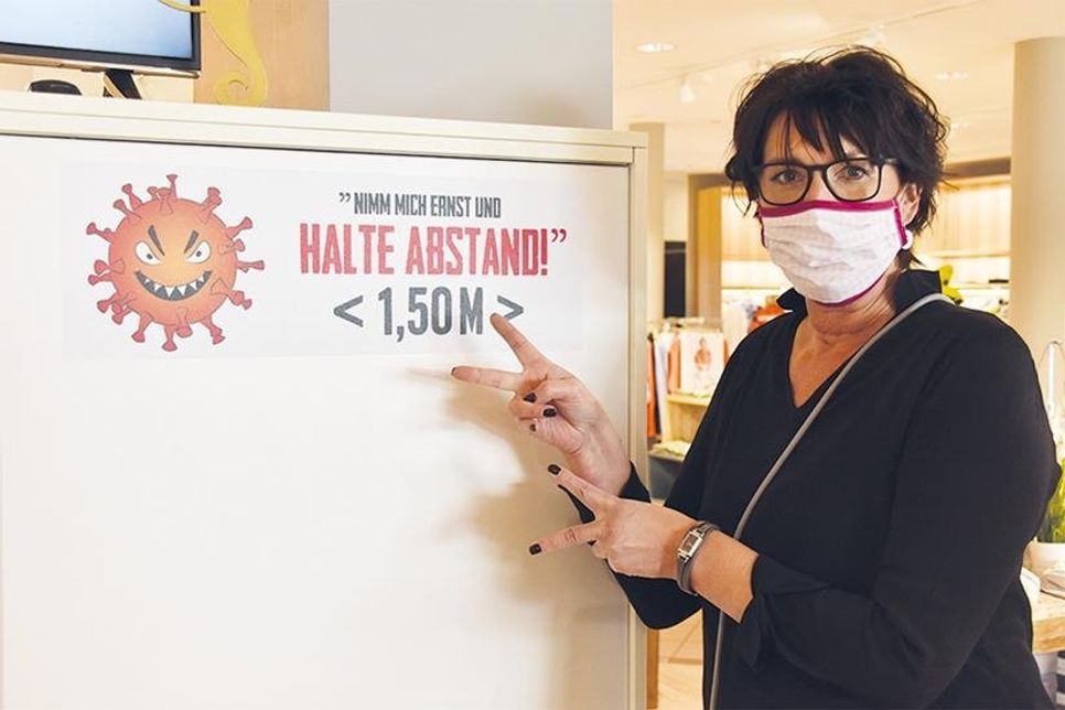 Alexandra Wohlfahrt, Teamleiterin bei Jaacks Mode &amp;amp; Schuhe in Niendorf/Ostsee, weist auf die Hinweisschilder hin.