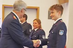 Die frischgebackene Feuerwehrfrau Jessika Junge (m.) freut sich mit Jaron Pichler (r.), den Gemeindewehrführer Jens Willrodt gerade zum Oberfeuerwehrmann befördert.