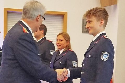 Die frischgebackene Feuerwehrfrau Jessika Junge (m.) freut sich mit Jaron Pichler (r.), den Gemeindewehrführer Jens Willrodt gerade zum Oberfeuerwehrmann befördert.