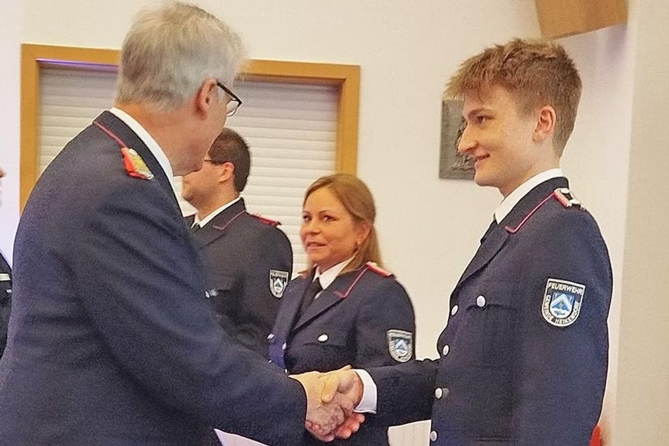 Die frischgebackene Feuerwehrfrau Jessika Junge (m.) freut sich mit Jaron Pichler (r.), den Gemeindewehrführer Jens Willrodt gerade zum Oberfeuerwehrmann befördert.