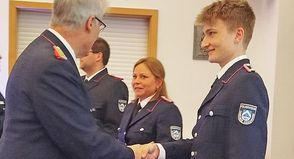 Die frischgebackene Feuerwehrfrau Jessika Junge (m.) freut sich mit Jaron Pichler (r.), den Gemeindewehrführer Jens Willrodt gerade zum Oberfeuerwehrmann befördert.