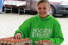 Wochenmarkt-Titelmädchen Josy deckt sich mit frischen Eiern für ein perfektes Osterfrühstück ein.
