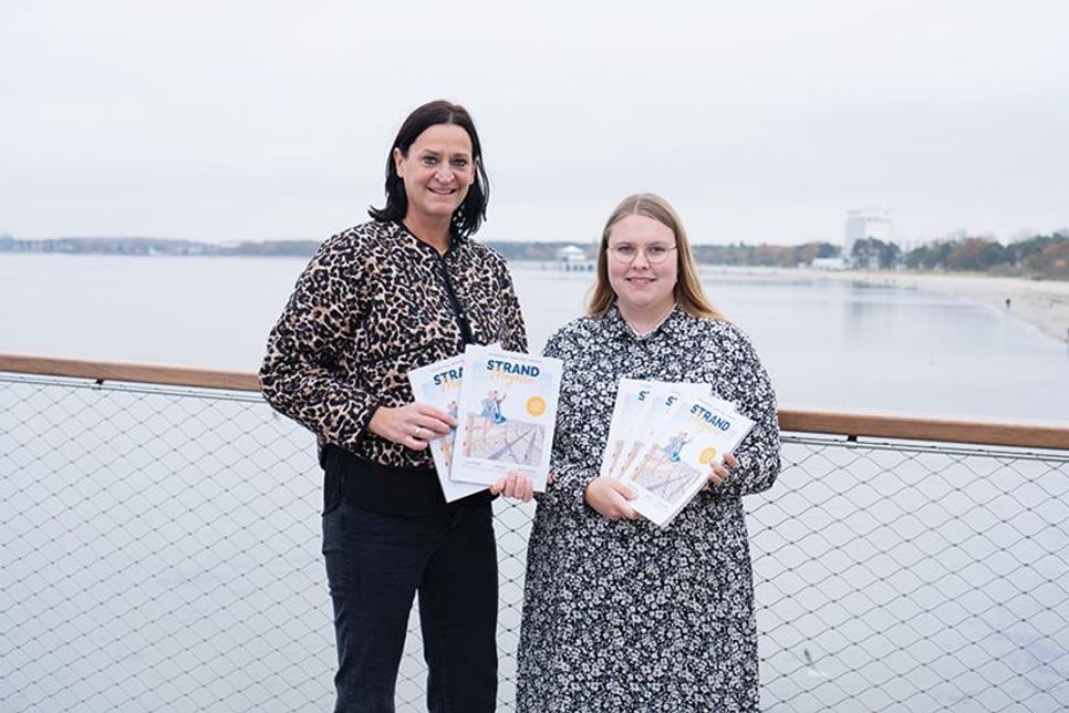 Silke Szymoniak, Marketingleiterin der TSNT GmbH (links), und Projekt- und Kampagnenmanagerin Lale Schoenberg präsentieren das neue „Strandmagazin 2025“.
