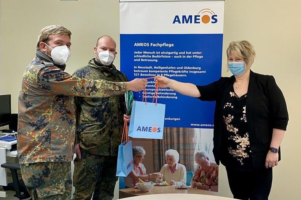 Christina Grahl, Direktorin der Pflegehäuser, begrüßt zwei der sechs Bundeswehrsoldaten, die in der Ameos Pflege in Holstein bei den Testungen unterstützen.