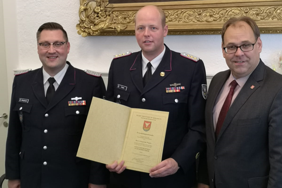 Alexander Wengelewski, Sebastian Papke mit der Ernennungsurkunde und Bürgermeister Mirko Spieckermann (v. lks.).