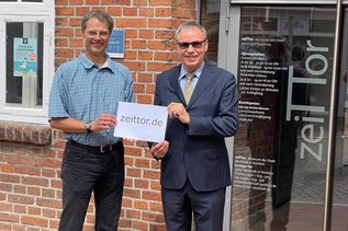 Museumsleiter Dr. Frank Wilschewski (lks.) erhält offiziell die gespendete Domain von Arne Maus.