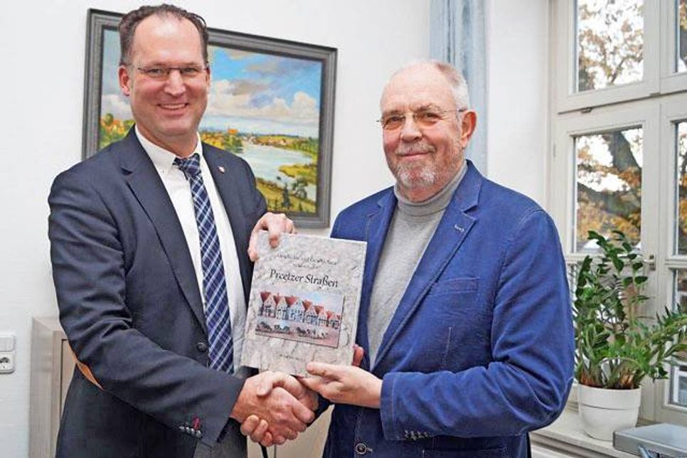 Schwebstöcken, Bäckergang, Gerberweg… Peter Pauselius (re.) hat viel Interessantes, Geschichtliches, Kurioses und manchmal auch Amüsantes über alte und neue Preetzer Straßen zusammengetragen. Bürgermeister Björn Demmin freut sich über das erste Exemplar.