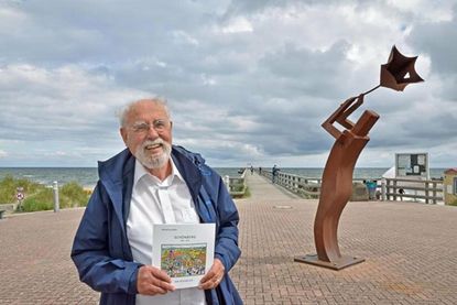 Altbürgermeister Wilfried Zurstraßen nutzte die Zeit der Pandemie, um ein Buch über die Schönberger Ereignisse in den Jahren seiner Amtszeit nach Art einer Chronik zu verfassen. Die Schönberger Seebrücke im Hintergrund ist eines der zentralen Bauprojekte gewesen.