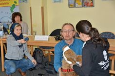 NDR-Redakteurin Astrid Wulf (links) fängt im Ton ein, wie Udo Galster und Ann-Christin Meyer (rechts)  einen Verband an der Schnauze von Übungshund ASBY anlegen, interessiert beobachtet von Ulrike Föse.