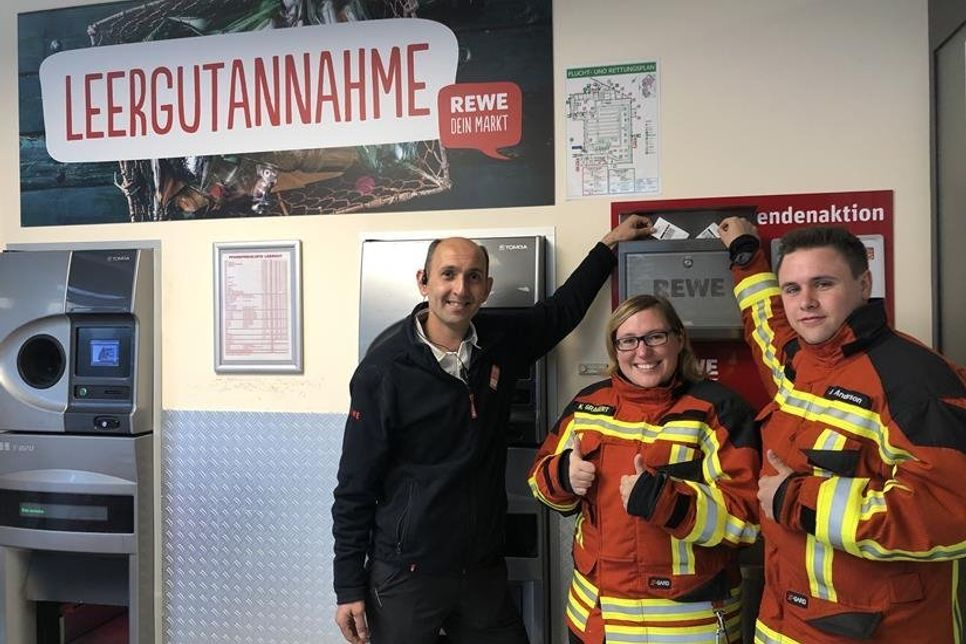 Marktleiter Ayhan Deniz mit der Leiterin der Kinderfeuerwehr Kerstin Gragert und dem stellvertretenden Jugendwart der Jugendfeuerwehr Bo Anderson (v. lks.).