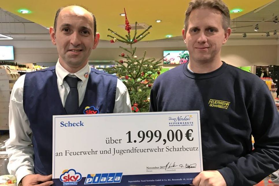 Die stolze Summe von 1.999 Euro wurde in Form eines Schecks symbolisch vom Marktleiter Ayhan Deniz an den Ortswehrführer Sebastian Levgrün übergeben.