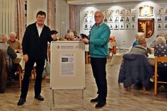 Rainer Figgen (Vorsitzender des Seniorenbeirats, re.) und Michael Suhr (Helfer und Wahlkandidat) präsentieren die neuen Schutzhüllen.