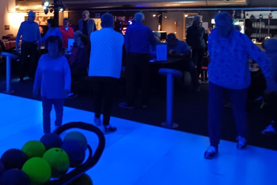 Seniorinnen und Senioren treffen sich zum Bowling.