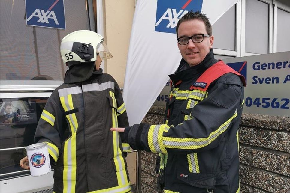 Ortswehrführer Jacob Revenstorf stellt „Elfriede“ vor, eine Schaufensterpuppe in Einsatzschutzkleidung, die in der Neustädter Straße 23 mit einer Spendendose auf potenzielle Unterstützer wartet.