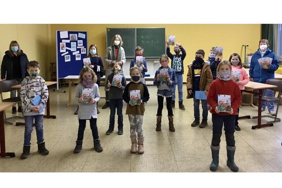 Zur Buchübergabe der „Förde-Detektive“ traf man sich mit Abstand und Maske, trotzdem ist die Freude bei der Landtagsabgeordneten Sandra Redmann (lks.), der Schulleitung Doris Jürs, der Schulverbandsvorsteherin Angela Hüttmann (re.) und dem gesamten Schülerparlament zu erkennen.