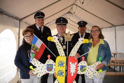 „Hans Holzfäller“ hieß der Vogel in diesem Jahr. Der bis dato amtierende Schützenkönig Kai Peter Liedtke (mi.) mit Familie sowie Wehrführer Hans-Werner Landschoof (2. v. lks.) und Vogelbauer Sven Ketturkat (2. v. re,) präsentieren das gute Stück.