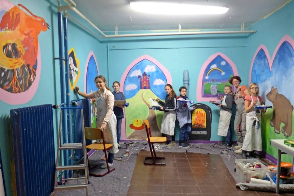 Innenarchitektin und Wandmalerin Anne Kraatz mit den Schülern im gemeinsam gestalteten „Fantasy Raum“.