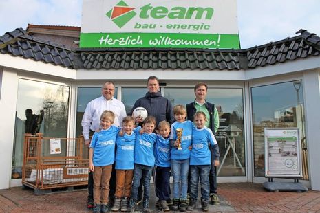 Baucenterleiter Holger Werner, Trainer Wolfgang Westphal und Fachberater Hendrik Alms (v. lks.) mit den stolzen Nachwuchsfußballern.