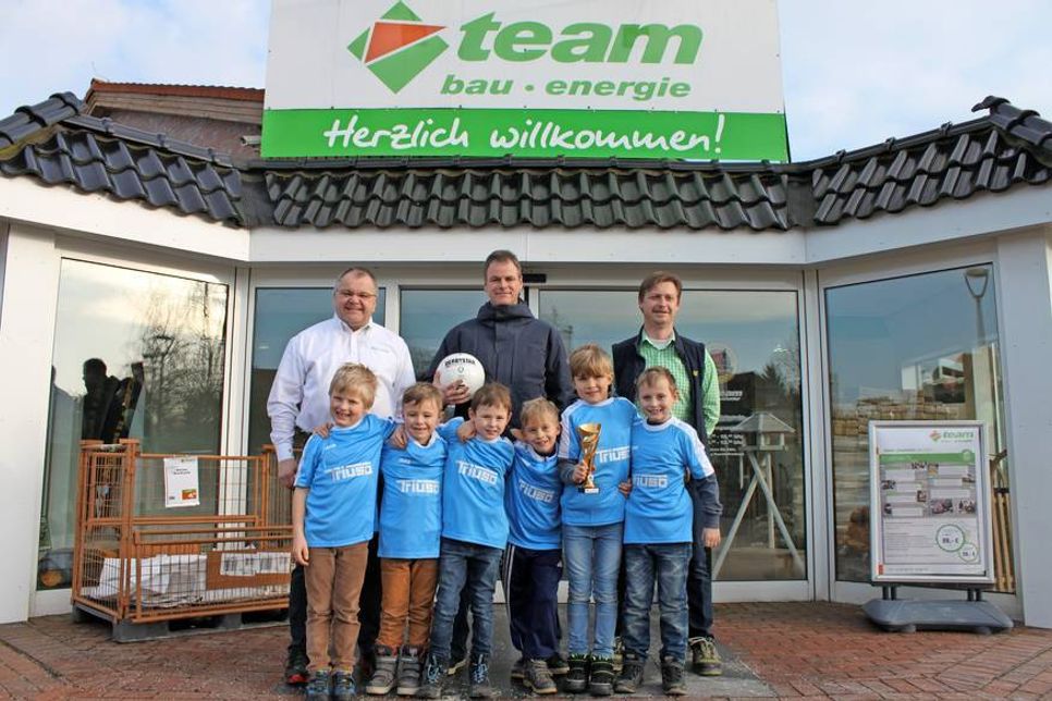 Baucenterleiter Holger Werner, Trainer Wolfgang Westphal und Fachberater Hendrik Alms (v. lks.) mit den stolzen Nachwuchsfußballern.