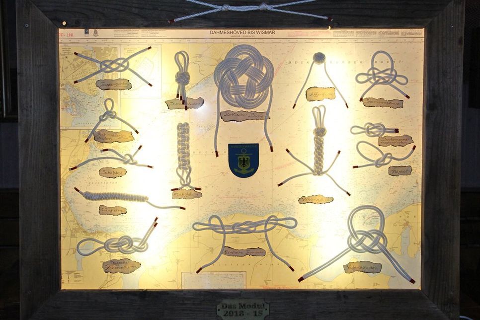 Die Tafel ist nach dem Leuchtkastenprinzip gebaut, umfasst seemännische Gebrauchsknoten, Zierknoten und einen Rahmen mit alten Eichendalben aus dem Hafen.
