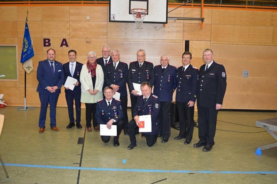 Landrat Timo Gaarz (lks.), Bürgermeister Thomas Keller (2. v. lks.), Kreispräsidentin Petra Kirner, Jörg Nero (re.) und Michael Hasselmann (2. v. re.) mit den Geehrten (hinten stehend v. lks.): Kai-Wilhelm Garken, Carsten Dede, Axel Behnk, Klaus Sindt sowie Rolf Müller (knieend lks.) und Axel Suhm.