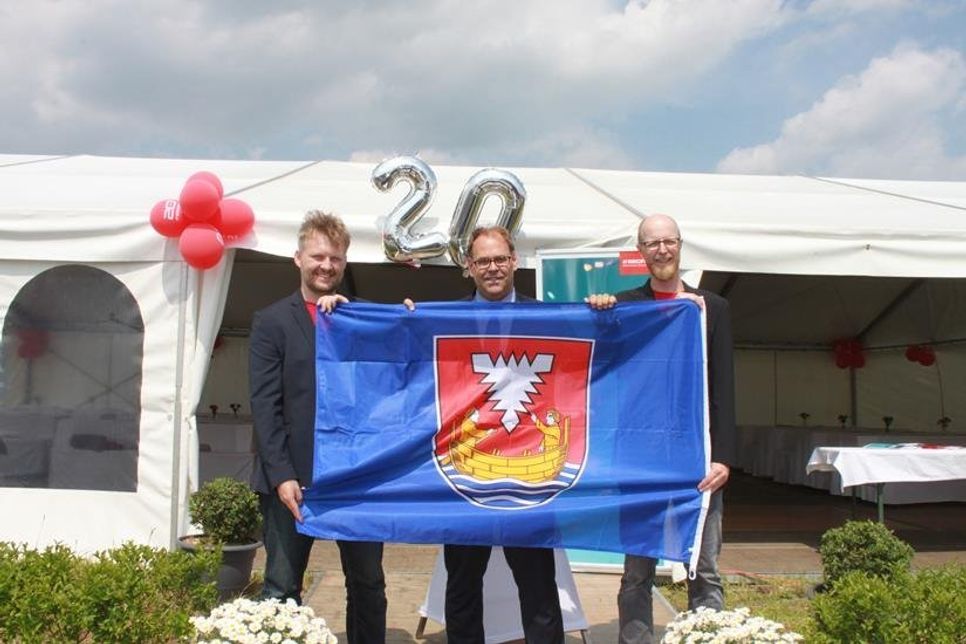 Bürgermeister Mirko Spieckermann (Mi.) überreichte die Flagge der Stadt Neustadt an die Geschäftsführer.