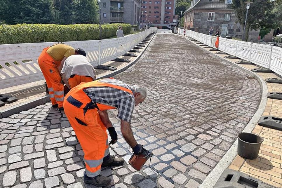 Damit die Fugenmasse besser aushärtet, wird die Fahrbahn mit Splitt abgestreut.