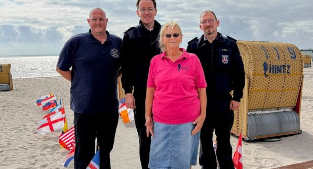 Im Rahmen der Spendenübergabe am Grömitzer Strand dankten (v. lks.). Alan Franke (Jugendfeuerwehr), Jacob Revenstorf (Ortswehrführer Feuerwehr Grömitz) und Manuel Rath (Feuerwehr Brenkenhagen) der Strandkorbvermieterin für die Unterstützung und Förderung des Ehrenamtes.