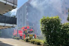 Dicke weiße und schwarze Rauchschwaden steigen in den strahlend blauen Himmel.