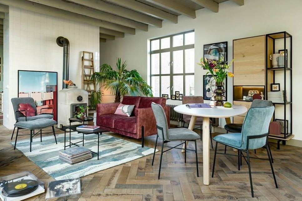 Ein kleiner, runder Tisch und ein hoher Schrank helfen dabei, die Wohnung platzsparend einzurichten.