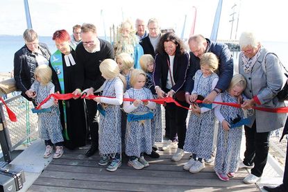 Das obligatorische Durchschneiden des roten Bandes im Beisein von Neptun und seinen Nixen, Bürgervorsteherin, Pastorin, Minister Madsen, Bürgermeisterin, Landrat und Kreispräsidentin.