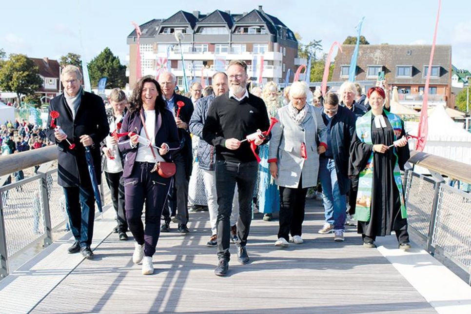 Der ehemalige Minister Bernd Buchholz (von links), Bürgermeister Bettina Schäfer und Wirtschafts- und Tourismusminister Claus Ruhe Madsen bei den ersten Schritten auf die neue Haffkruger Seebrücke, dahinter in der zweiten Reihe Bürgervorsteherin Anja Bendfeldt (v.li.), Reinhard Sager, Landrat Timo Gaarz und Kreispräsidentin Petra Kirner sowie Pastorin Kristina Warnemünde (ganz rechts).