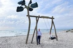 „Auf die Schaukel, fertig, los!“: Jacqueline Schumacher vom Tourismus-Service Grömitz und Manfred Wohnrade zeigen am neuen Standort an der Wiese Uferstraße, wie viel Spaß die beliebte Grömitz-Schaukel mit Ostseeblick macht.