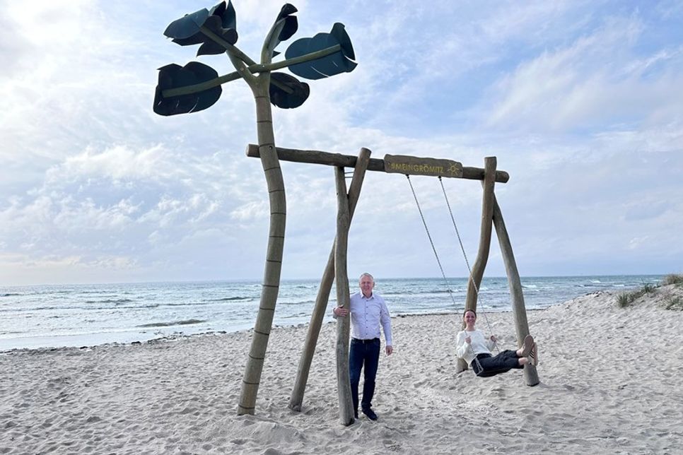 „Auf die Schaukel, fertig, los!“: Jacqueline Schumacher vom Tourismus-Service Grömitz und Manfred Wohnrade zeigen am neuen Standort an der Wiese Uferstraße, wie viel Spaß die beliebte Grömitz-Schaukel mit Ostseeblick macht.