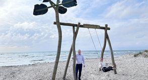 „Auf die Schaukel, fertig, los!“: Jacqueline Schumacher vom Tourismus-Service Grömitz und Manfred Wohnrade zeigen am neuen Standort an der Wiese Uferstraße, wie viel Spaß die beliebte Grömitz-Schaukel mit Ostseeblick macht.