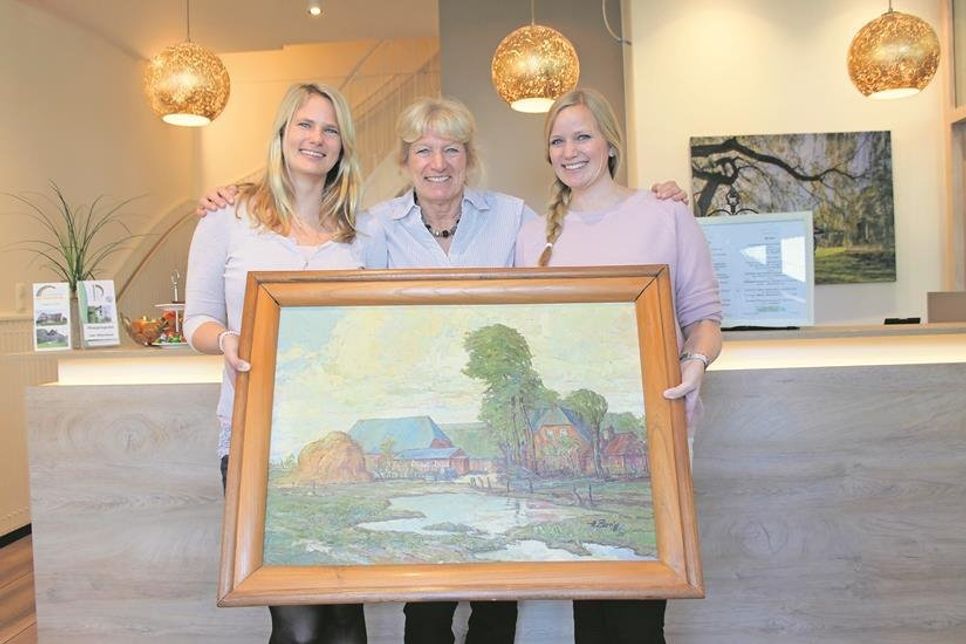 Sybill Langbehn (Mi.) mit ihren Töchtern Kristin (lks.) und Hanna sowie einem Ölgemälde des alten Gutshofs von 1950.