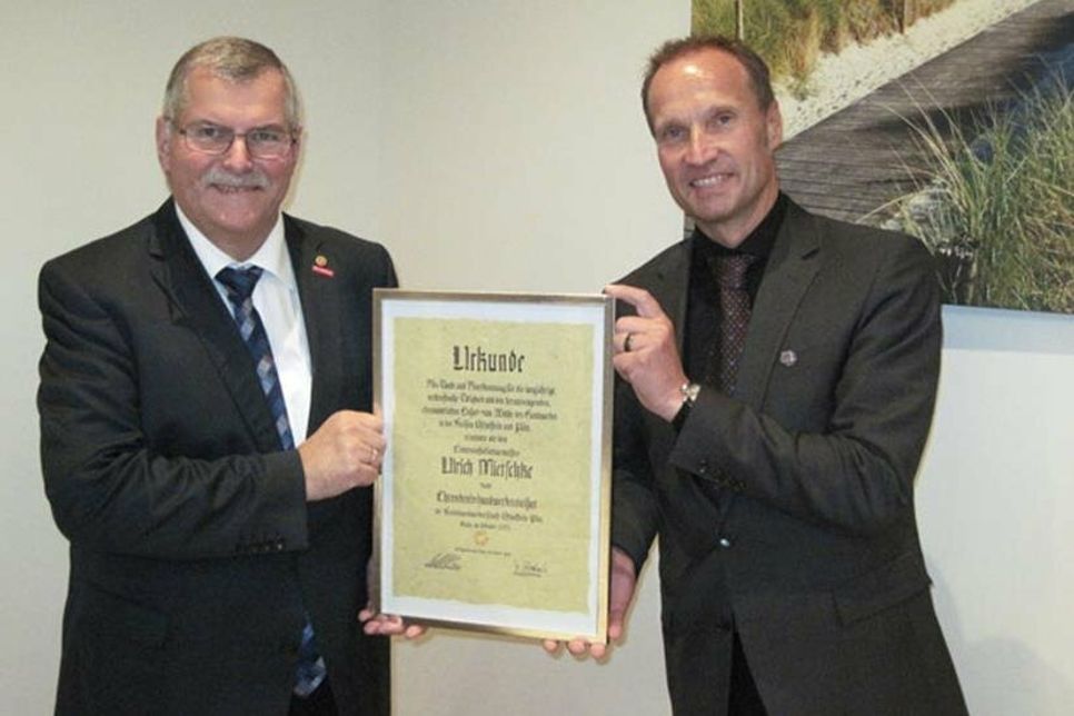 Thoralf Volkens (rechts) überreicht Ulrich Mietschke die Ernennungsurkunde zum Ehrenkreishandwerksmeister