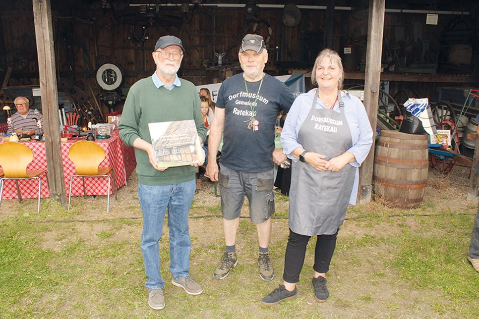 Jeanette Mohr und Dieter Witt aus dem Vorstand des Vereins Dorfmuseum Gemeinde Ratekau zeichneten Harald Gerhard für seine Verdienste mit einem Bildband über das Dorfmuseum aus.