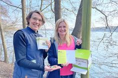 Stephanie Fahnemann vom Naturpark Holsteinische Schweiz und Caroline Backmann, Tourismuszentrale Holsteinische Schweiz, präsentierten einen der neuen Stempelkästen am Schöhsee-Wanderweg in Plön.