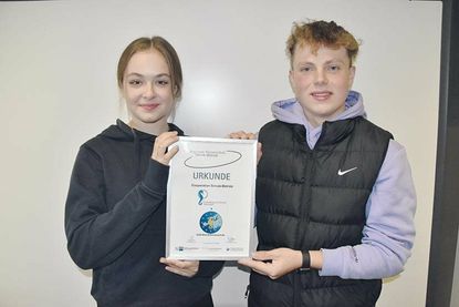 Das neue Schülersprecher-Duo Emelia Rizzuti und Til Gosch mit den Urkunden zur Kooperationsvereinbarung zwischen ihrer Schule und der TSNT GmbH.