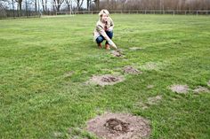 1. Vorsitzende Claudia Piutti zeigt den schlechten Zustand des Rasenplatzes.