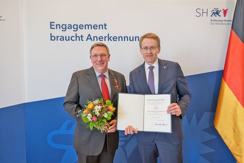 Ministerpräsident Daniel Günther zeichnete Bühnenleiter Jan Steffen für sein Engagement für die Plattdeutsche Sprache aus und überreichte das Bundesverdienstkreuz am Bande und die Urkunde des Bundespräsidenten Frank-Walter Steinmeier.