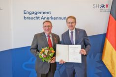 Ministerpräsident Daniel Günther zeichnete Bühnenleiter Jan Steffen für sein Engagement für die Plattdeutsche Sprache aus und überreichte das Bundesverdienstkreuz am Bande und die Urkunde des Bundespräsidenten Frank-Walter Steinmeier.