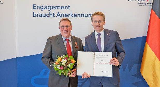 Ministerpräsident Daniel Günther zeichnete Bühnenleiter Jan Steffen für sein Engagement für die Plattdeutsche Sprache aus und überreichte das Bundesverdienstkreuz am Bande und die Urkunde des Bundespräsidenten Frank-Walter Steinmeier.
