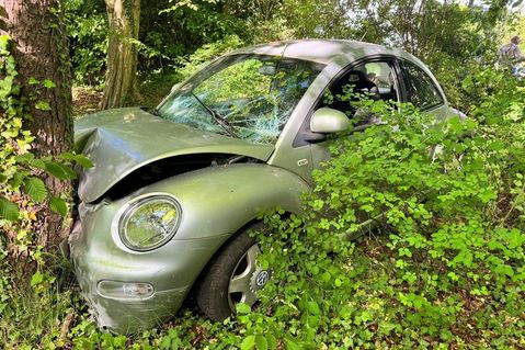 Der Pkw kam von der Fahrbahn ab, durchbrach einen Metallzaun, landete auf dem bewachsenen Grundstück und prallte gegen einen Baum.