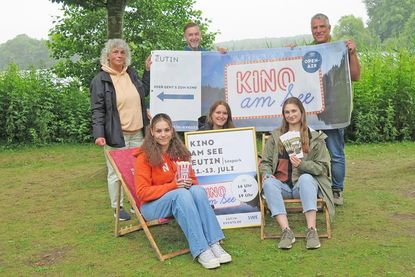 Sommerzeit ist Kinozeit im Seepark in Eutin. Und auch in diesem Jahr wartet ein Programm mit Spaß und Unterhaltung für alle Generationen. Während Eva Staege, Michael Keller und Torsten Medloff (stehend v. l.) von der Touristik-GmbH das Werbe-Banner und Auszubildende Kimberly Schoering das Plakat für das „Kinoevent am See“ präsentieren, haben sich mit Victoria Meier und Lara Kuhlmann zwei weitere Auszubildende fürs Pressefoto in den Liegestühlen platziert.