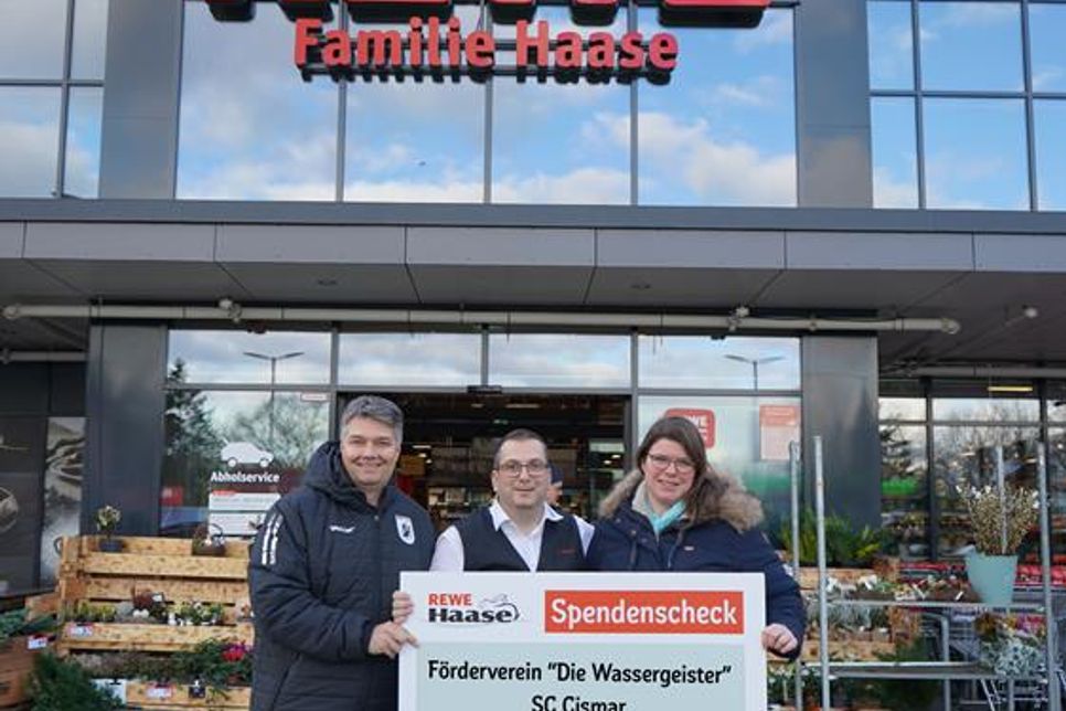 Vor dem Rewe-Markt der Familie Haase nahmen die Vereinsvertreter den Spendenscheck entgegen.