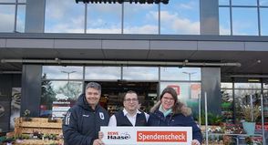 Vor dem Rewe-Markt der Familie Haase nahmen die Vereinsvertreter den Spendenscheck entgegen.
