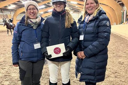 Nathalie Enge (lks.) und Vanessa Rutting (re.) vom Vereinsvorstand RuFV Neustadt gemeinsam mit Mia Jolie Schnack bei der Siegerehrung der L Dressur.